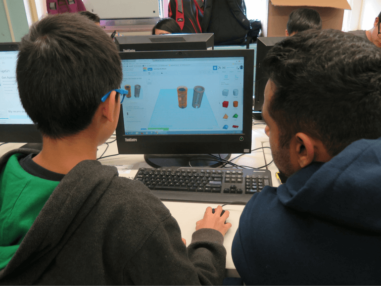 educator assisting male student in designing a 3D object on Tinkercad.com