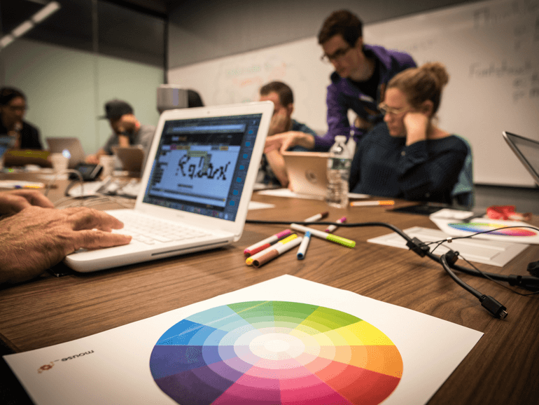 Image of color wheel and people working on intro to design course